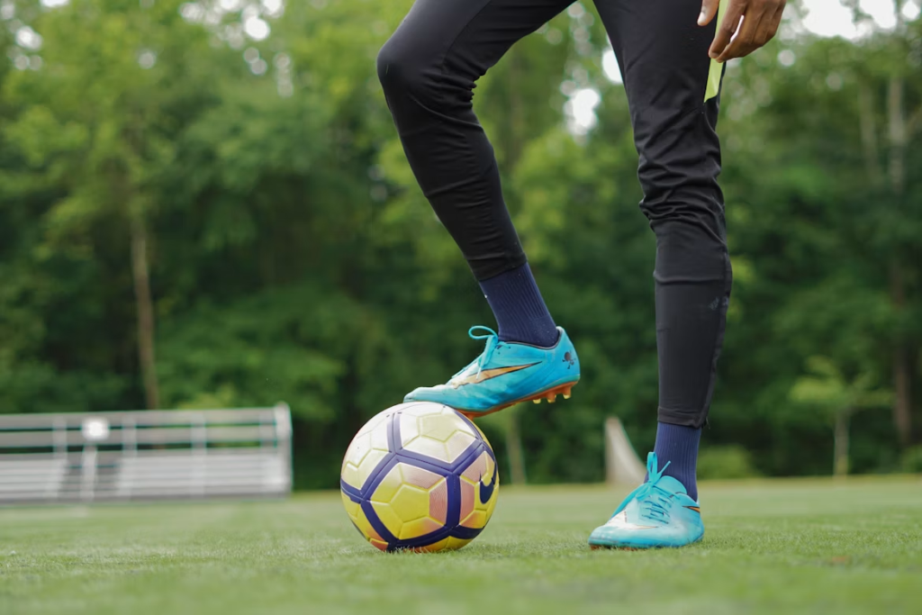 personne en chaussures de foot bleues et pantalon noir