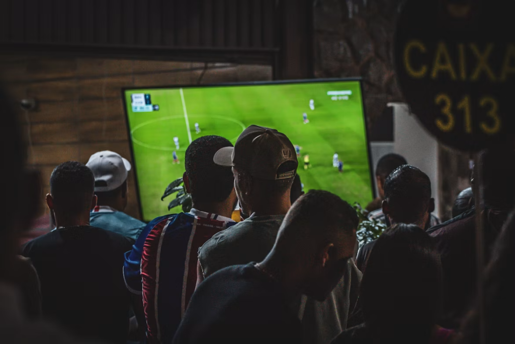 un groupe de personnes regardant un match de football à la télévision